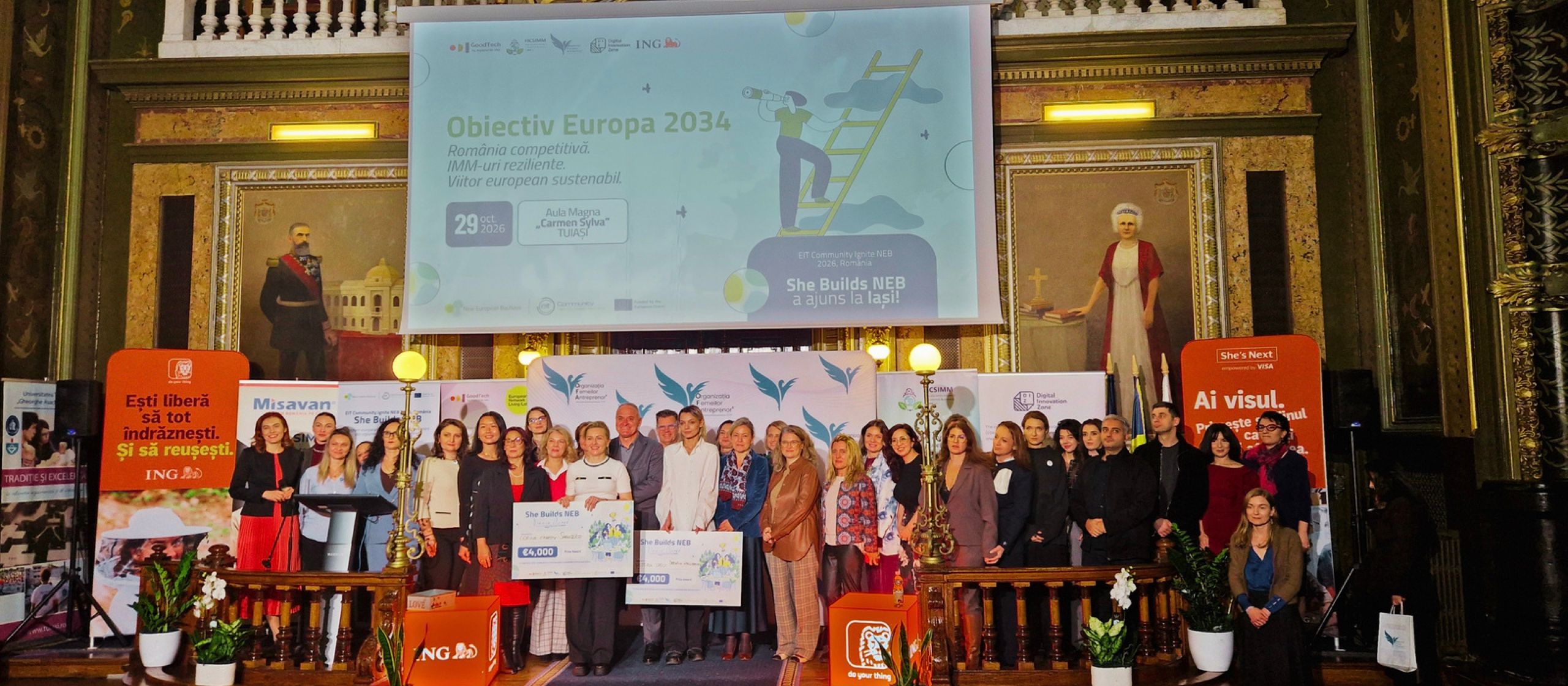 Finalists, organisers and partners of She Builds NEB together on stage in the Aula Magna in Iași, with the winners holding their awards.